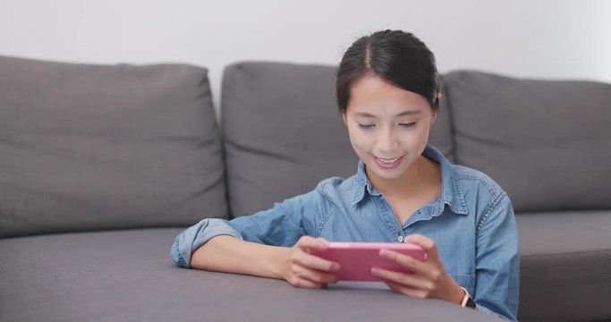 Woman play game on cellphone at home