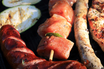 A set of meats baked on the grill during a family picnic in free time. Summer relaxation in the open air.