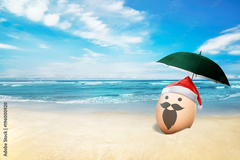 Wall mural egg with santa hat in the beach