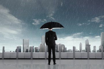 Businessman in the rain with umbrella