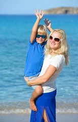 Happy mother with son on beach on a sunny summer day