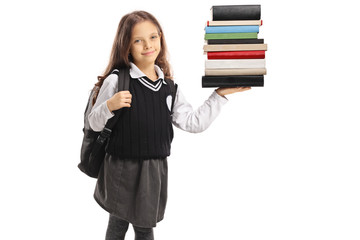 Little schoolgirl holding a stack of books
