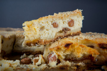 closeup piece of cheesecake stands on whole pie