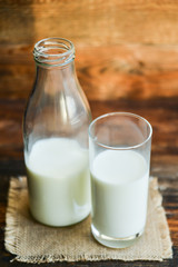 glass of milk, cow on natural wooden background in rustic style, rural style, concept of natural products and farming