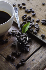 Cup of coffee and coffee beans on wooden table