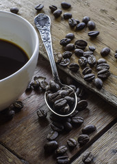 Cup of coffee and coffee beans on wooden table
