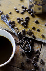 Cup of coffee and coffee beans on wooden table