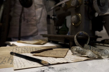 Designer pencil on ideas paper with dark background of sewing machine in tailor shop