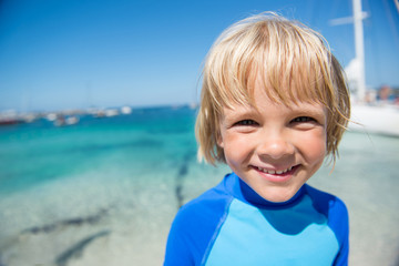 Happy little boy on the beach during summer vacations