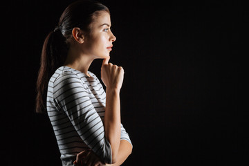Naklejka premium Just think. Deep cute stylish woman being in the empty room touching to her chin and thinking.