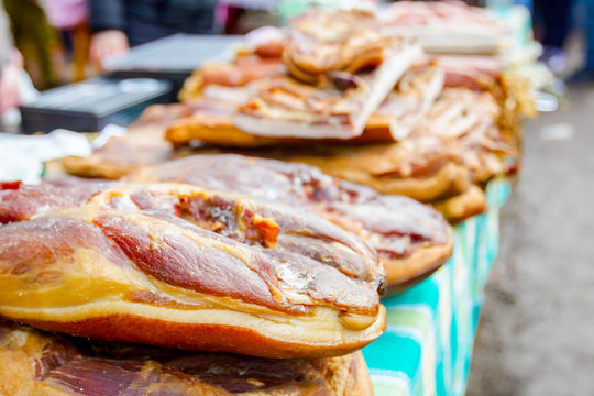 Selling smoked bacon, meat on stall, street market