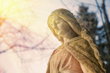 Virgin Mary statue. Vintage sculpture of sad woman (Religion, faith, suffering, love concept)