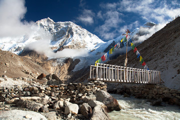 Mount Makalu with clouds, vooden bridge and river