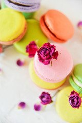 Delicate Fresh Colorful French Macaroons In Pastel Colors With Flowers Roses On A Light Textile Background