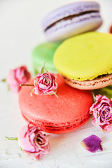 Delicate French Macaroons With Fresh Flowers Roses On Light Background