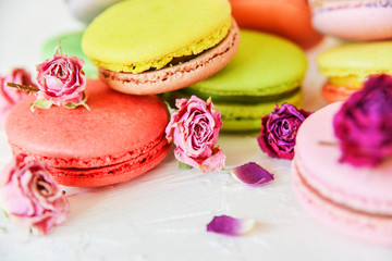Delicate Fresh Colorful French Macaroons In Pastel Colors With Flowers Roses On A Light Textile Background