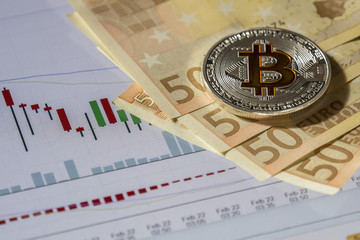 Cryptocurrency coins over buy and sell trading graphic and euro banknotes; Bitcoin  coins