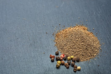 Mix of grind black pepper and black, white, red and yellow peppercorn. Selective focus.
