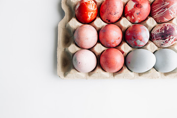 Colorful painted Easter eggs in egg carton, festive background