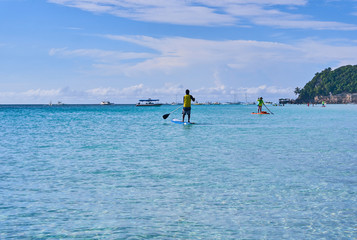 People are enjoying a view in standup paddleboarding over the ocean