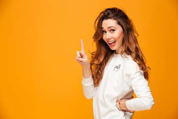 Happy brunette woman in sweater posing with arm on hip