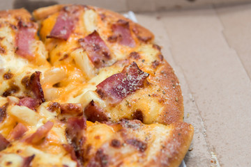 Close up of pizzas with variety of toppings and cheese in cardboard take out boxes with open lid