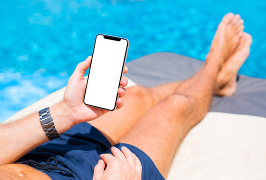 Man using mobile phone on vacation by the pool. Mobile phone mockup.