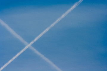 a streak of intersection of two  planes flying in the clear blue sky