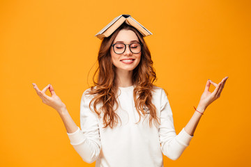 Pleased brunette woman in sweater and eyeglasses meditation