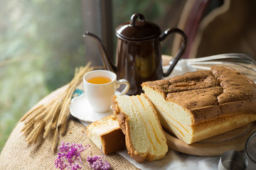 Hot tea cup and butter cake on Sack background