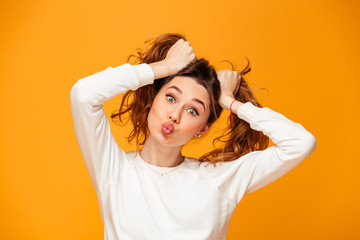Funny brunette woman in sweater holding her hair