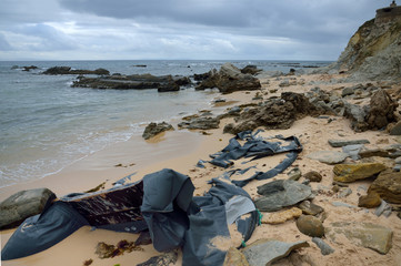 REMAINS OF A WRECKED DINGHY ON A BEACH OF THE STRAIT OF GIBRALTAR