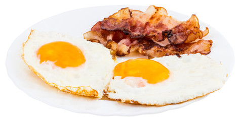 Plate with fried eggs and bacon on white background