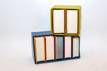 Stack of small books in hard cover on a white background
