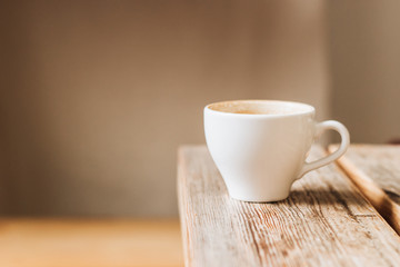 White cup of coffee on wooden table