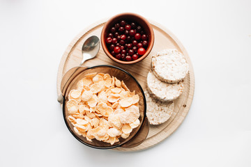 Crisp bread slices and fresh cranberries on wooden board isolated over white background, healthy breakfast