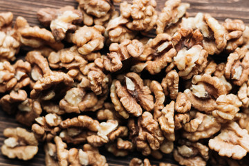 Pile of shelled walnuts on wooden background, healthy eating concept