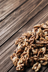 Pile of shelled walnuts on wooden background, healthy eating concept