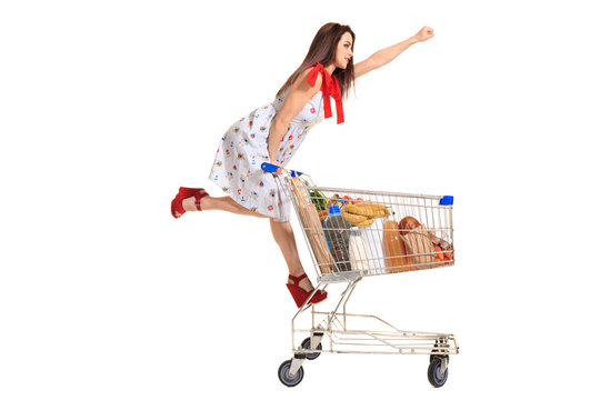 Woman With Shopping Cart Full With Products Isolated Over White Background