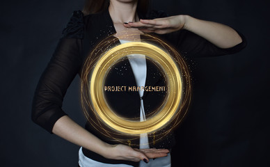 In the hands of a businessman, a neon circle with the inscription:PROJECT MANAGEMENT