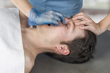 Obraz na płótnie Canvas Physiotherapist, chiropractor doing a sinus massage, therapy. Osteopathy.