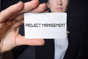 Businessman shows business card with the inscription:PROJECT MANAGEMENT