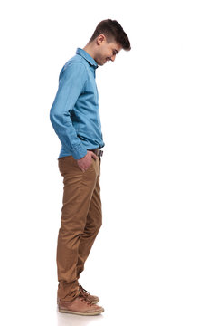 side view of a  casual man looking down at something