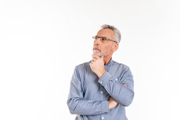Thoughtful man looking up at copy space while standing isolated