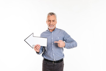 Old man in blue shirt pointing and holding arrow left isolated