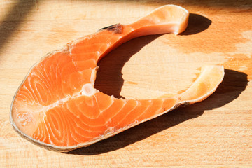Fresh raw salmon fillet on board, closeup