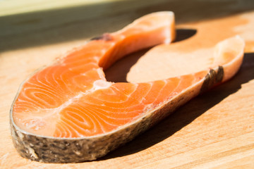 Fresh raw salmon fillet on board, closeup