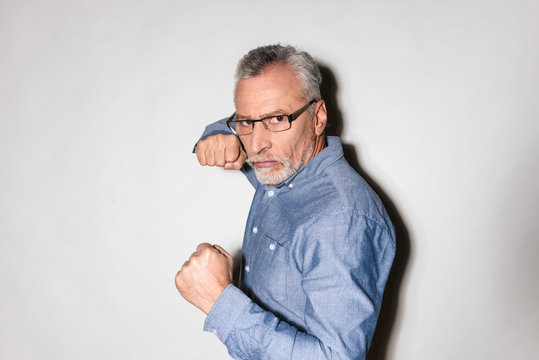 Mature man ready to fight and looking camera isolated