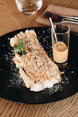 Piece of delicious fresh Napoleon cake with crumbs and cocktail