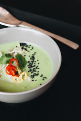 Delicious green spicy soup in white bowl